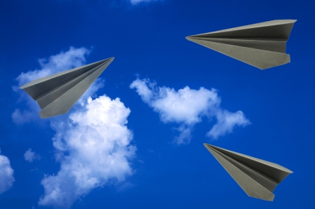 origami dark gray paper planes on blue sky backgroundの写真素材