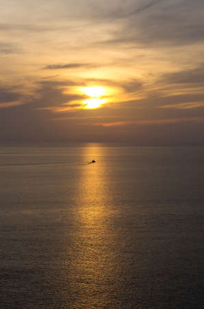 sunset on the sea with tradition fishing boatの写真素材
