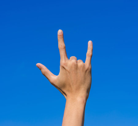 hands forming the love with blue sky