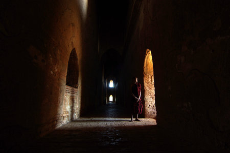 BAGAN, MYANMAR- JAN 5: Unidentified monk standing at window in Old Bagan, Myanmar on January 15, 2011. 89% of the Burmese population is Buddhist.のeditorial素材