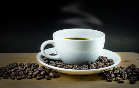 Coffee cup and beans on black background.