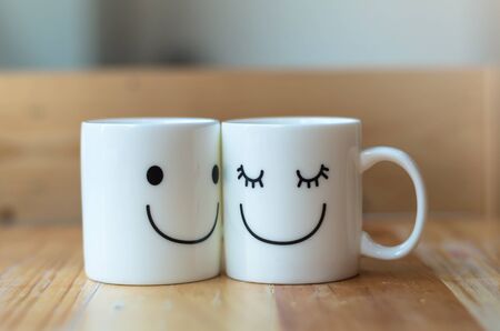 Two happy cups on wood table with bokeh, about love conceptの写真素材