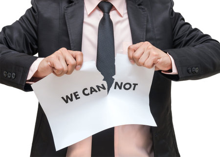 Businessman ripping up the we can not sign on white backgroundの写真素材