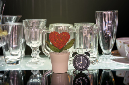 Heart and clock with various glasses on black backgroundの写真素材