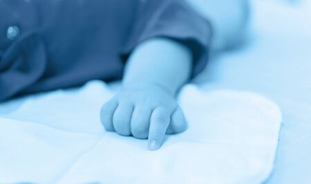 baby hand on the bedの写真素材