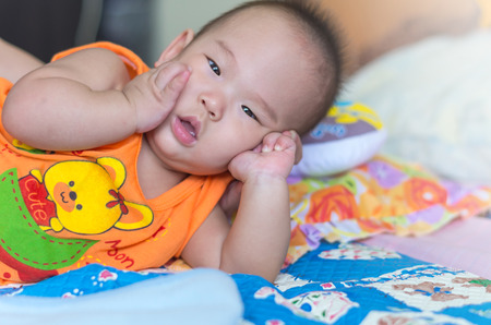 Portrait of happy asian baby on the bedの写真素材