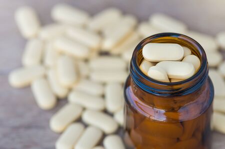 Pills or vitamin in Medicine bottles on wood backgroundの写真素材