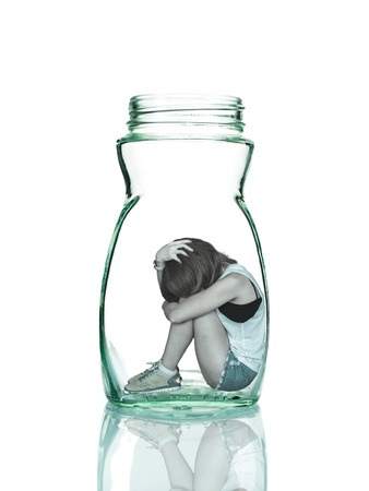 Sad woman sitting alone in a jarの写真素材