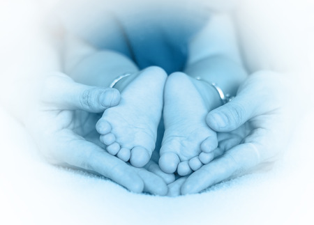Baby feet on the mothers handの写真素材