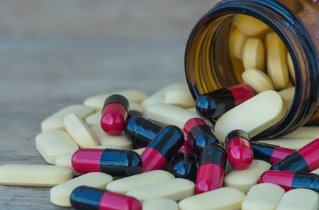 Many Pills and vitamin in Medicine bottles on wood backgroundの写真素材