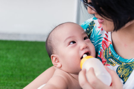 Asian baby drinking milk with mother