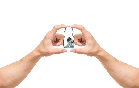man hands catching the Sad woman sitting alone in a jar on white backgroundの写真素材