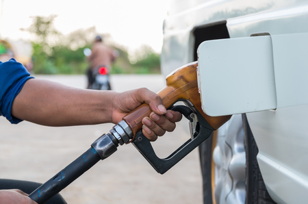 Hand hold Fuel nozzle to add fuel in car at filling stationの写真素材