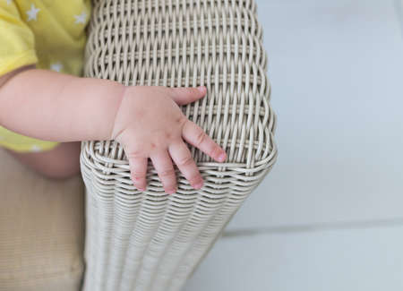 baby hand on weave bamboo chairの写真素材