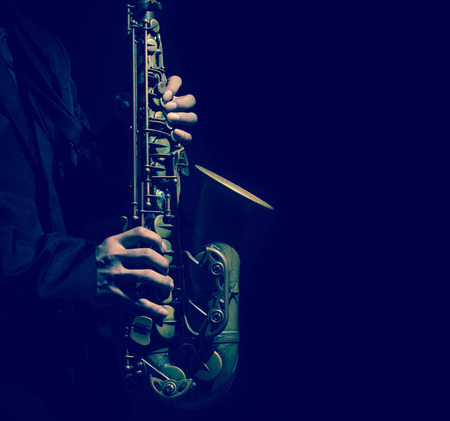 Closeup saxophone in player action on a dark background, dark blue toneの写真素材