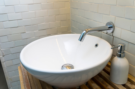 Chrome faucet with washbasin in modern bathroomの写真素材