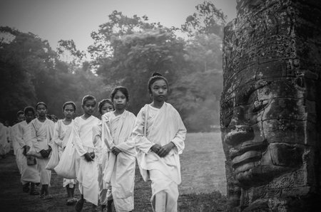 SIEMREAP, CAMBODIA - MAY 3 : Many unidentified Buddhist nuns girls in white suit walking for celebrate Buddhist Sabbath at Angkor wat at morning on May 3, 2015 in Siem Reap, Cambodiaのeditorial素材