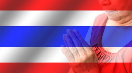 Old woman praying on Thailand flag backgroundの写真素材
