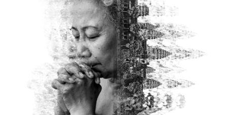 Double exposure and Disintegration of old woman praying with Angkor Wat at Siem Reap. Cambodia, black and white toneの写真素材