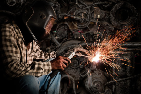 welder at work with old machine steel background, industry concept