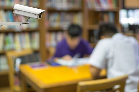 CCTV security camera on monitor the abstract Blurred photo of student reading in libraryの写真素材