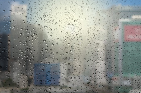 Waterdrops on a glass surface windows with cityscape background