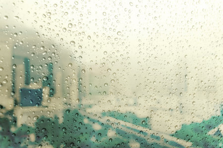 Waterdrops on a glass surface windows with cityscape background