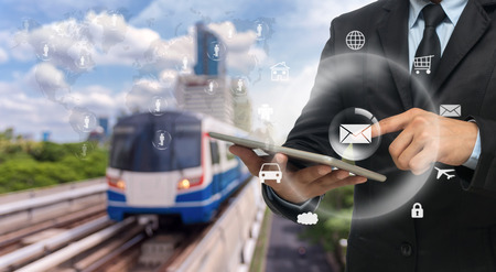 Businessman using the tablet on abstract Blurred photo of sky train with traffic and cityscapeの写真素材