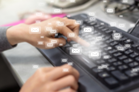 Many e-mail over the finger pressing the computer keyboard blurred background, business technology conceptの写真素材