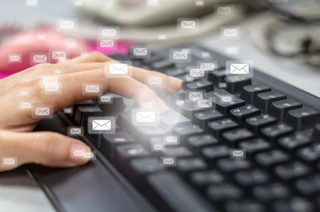 Many e-mail over the finger pressing the computer keyboard blurred background, business technology conceptの写真素材