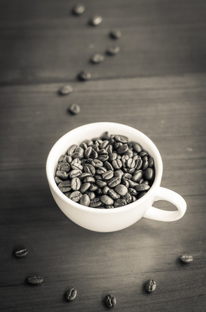 Coffee beans in coffee cup on wood with smoke and smile from coffee beans,vintage toneの写真素材