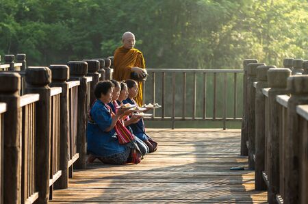 NAKHON RATCHASIMA, THAILAND - OCTOBER 31: Undefined People are preparing food for alms to Buddhist monk on wooden walkway on October 31,2015 in Nakhon ratchasima, Thailand.のeditorial素材