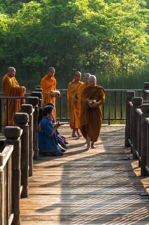 NAKHON RATCHASIMA, THAILAND - OCTOBER 31: Undefined People are preparing food for alms to Buddhist monks on wooden walkway on October 31,2015 in Nakhon ratchasima, Thailand.のeditorial素材