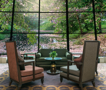 Lobby area of a hotel which can see row of Pink Trumpet Tree in the park with lakeの写真素材