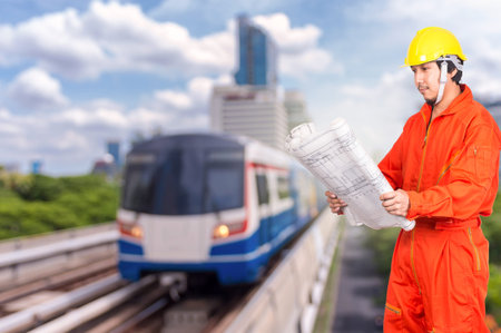 Portrait of Asian engineers looking at the blueprint on abstract Blurred photo of sky train,...