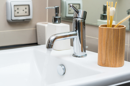 Chrome faucet with washbasin in modern bathroomの写真素材