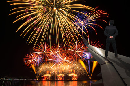 businessman standing on airplane wing which can see Fantastic festive colorful fireworks, Challenge...