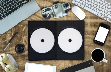 Top view of empty disk with cover and office accessory on wooden background, technology equipment mockup, flat layの写真素材