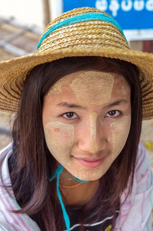 MANDALAY, MYANMAR - MARCH 12 : Unidentified Burmese girl with traditional thanaka on her face on March 12, 2016 in Mandalay, Myanmar.Thanaka is a yellowish-white cosmetic paste made from ground barkのeditorial素材