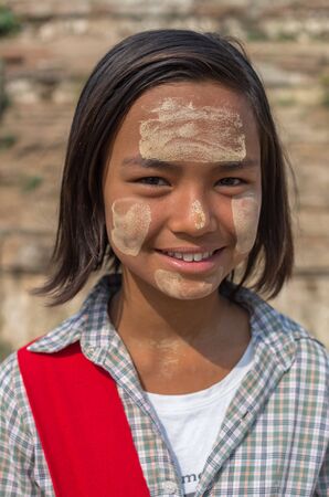 MANDALAY, MYANMAR - MARCH 12 : Unidentified Burmese girl with traditional thanaka on her face on March 12, 2016 in Mandalay, Myanmar.Thanaka is a yellowish-white cosmetic paste made from ground barkのeditorial素材