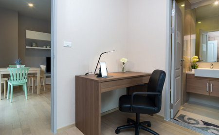 working table zone with tablet on the wood table with living room and restroom