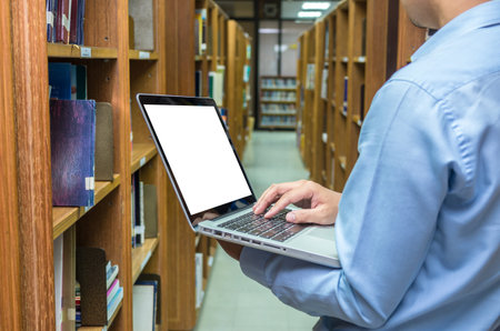 Businessman using the laptop conputer in the library, education and business concept
