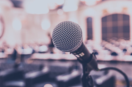 Microphone over the Abstract blurred photo of conference hall or seminar room background