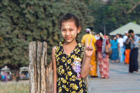 MANDALAY, MYANMAR - MARCH 13 : Unidentified Burmese girl smiling at the ubein bridge on March 13, 2016 in Mandalay, Myanmar. The U-Bein bridge is the longest teak bridge in the world, 1.2km length.のeditorial素材