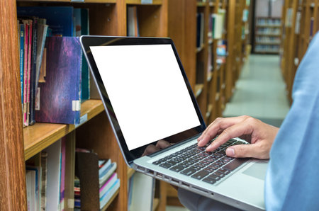 Businessman using the laptop conputer in the library, education and business conceptの写真素材