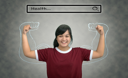Asian strong girl teenage with browsing of Internet searching bar with "Health" above the head on the wall background, Health conceptの写真素材