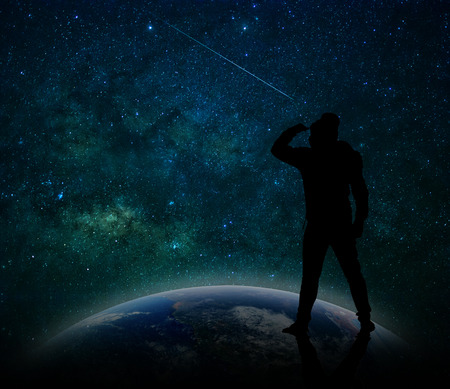silhouette of a man who standing on the earth and looking to milky way background, Elements of this image furnished by NASAの写真素材