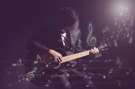 Musician playing the guitar with music notes or melody on dark background,music conceptの写真素材