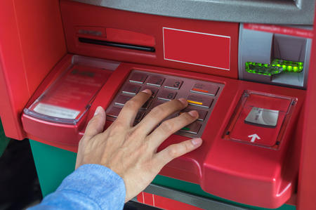 Closeup of male hands pressing the ATM EPP keyboard, business technology banking conceptの写真素材