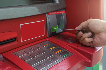 Closeup of male hands using and with insert ATM card into bank machine for withdraw the money, business technology banking conceptの写真素材